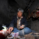 Quan Youzhi, 66, counts money in her dwelling inside an underground shaft in Beijing, December 5, 2013. According to local media, around five underground shafts, in which people were living in, were blocked by city officials on Friday morning at a neighbourhood in Beijing. One of the dwellers, Quan Youzhi, 66, has been living in the shafts, which were originally used for the city's heating system, for around 20 years as she could not afford to pay rent for housing after she came to Beijing, and has since relocated several times after being chased away by law enforcement officials. Quan supports herself with about 10 yuan ($1.64) daily, which she makes from collecting waste bottles. Picture taken December 5, 2013.